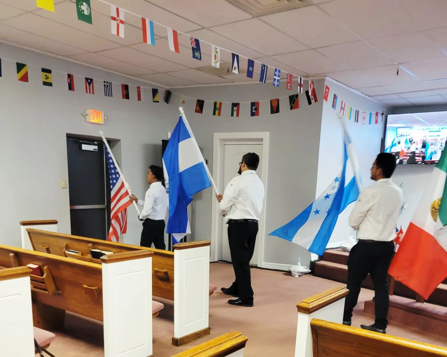 Equipo de misiones de la Iglesia Cristiana Pacto de Gracia en Charlotte participando en actividades misioneras, llevando la Palabra de Dios y representando a la iglesia en encuentros internacionales con banderas y símbolos de unidad.
