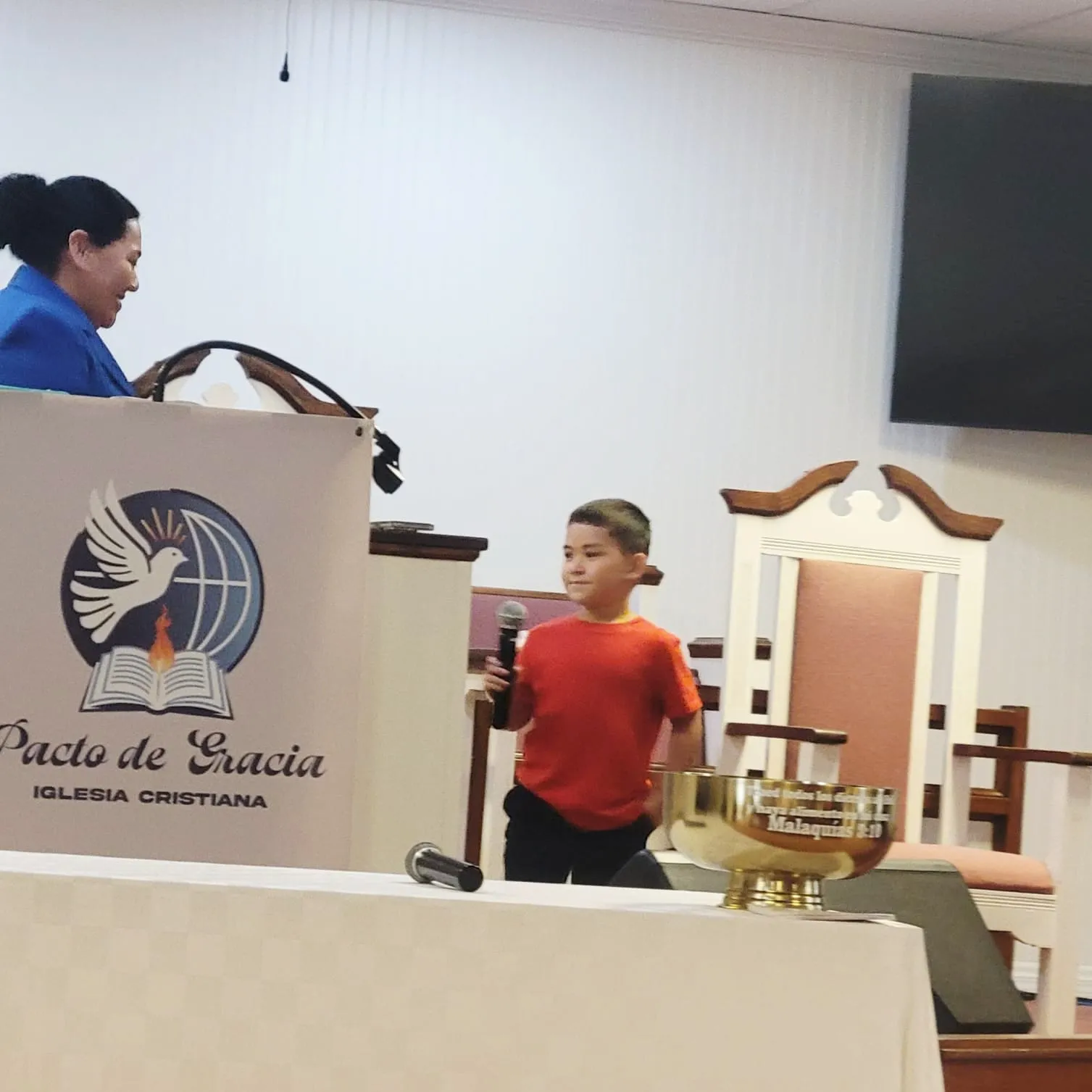 Niño participando en la Iglesia Cristiana Pacto de Gracia en Charlotte, alabando y sirviendo al Señor durante un culto especial.