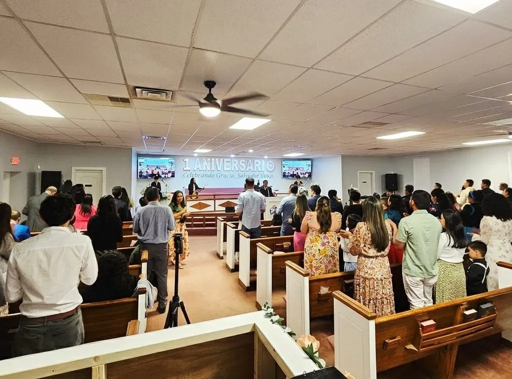 Congregación de la Iglesia Cristiana Pacto de Gracia en Charlotte celebrando el primer aniversario, con músicos y líderes al frente en el altar durante el culto especial.