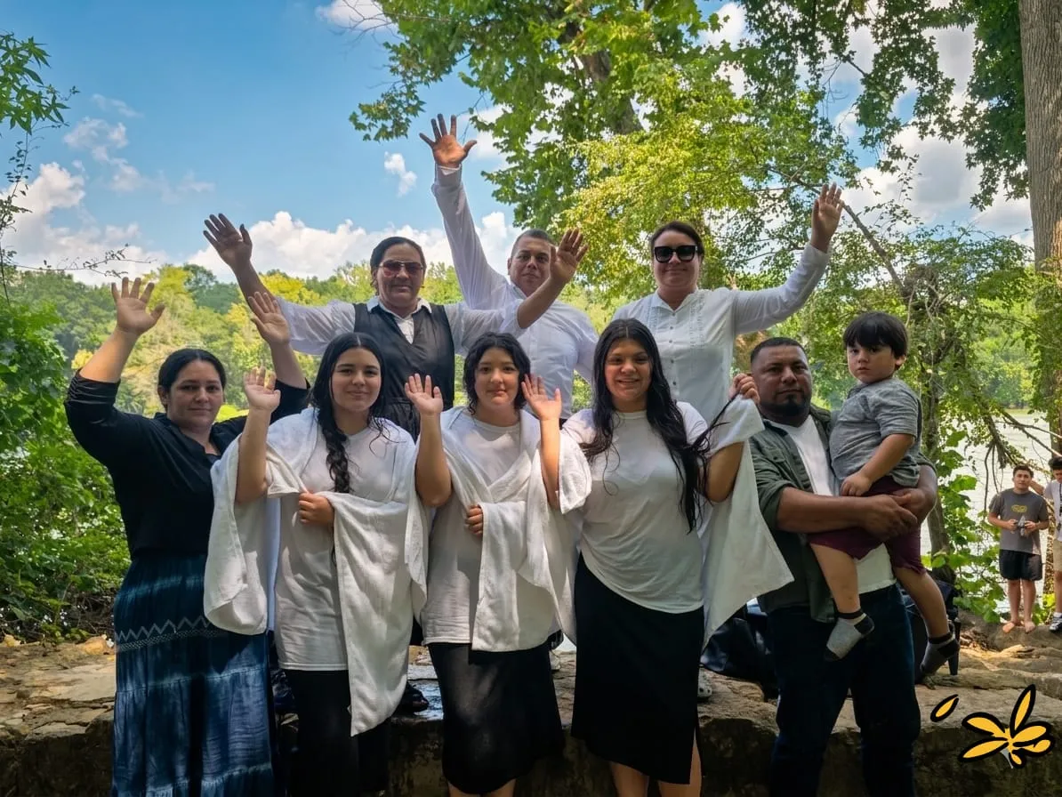 Bautizos en la Iglesia Cristiana Pacto de Gracia en Charlotte, con hermanos y hermanas vestidos de blanco celebrando en unidad y alegría en un ambiente natural.